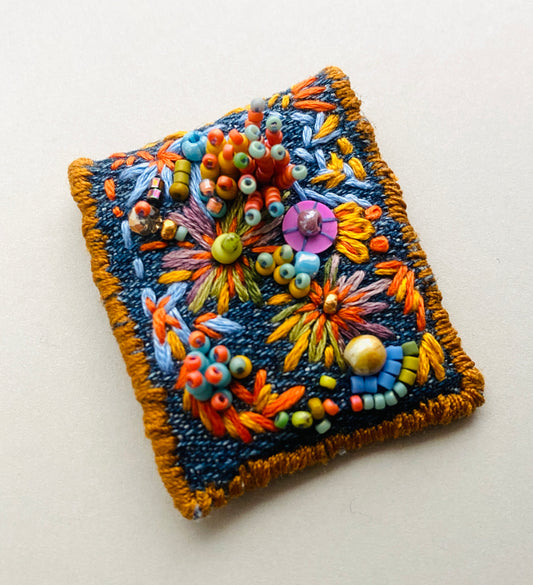 "Zinnias" Light blue and orange embroidered, beaded textile necklace.
