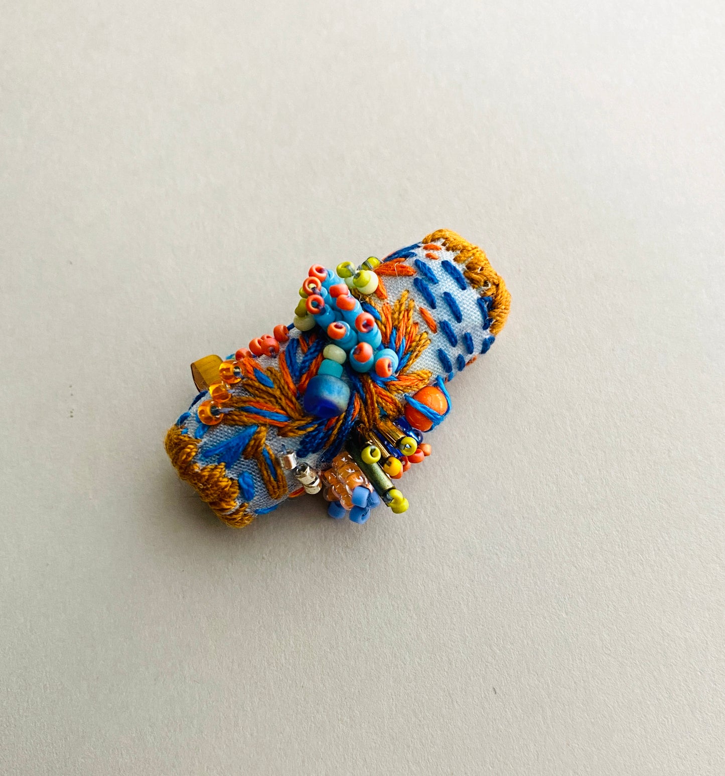"Horizon" Blue and orange embroidered and beaded textile necklace.