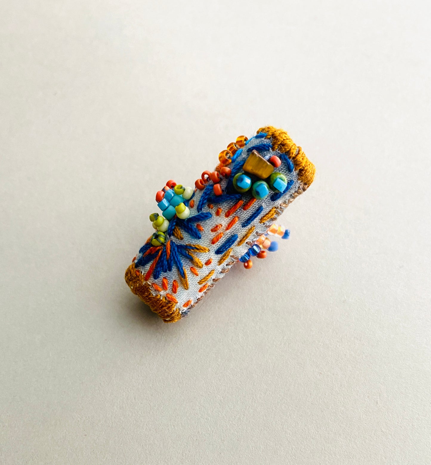 "Horizon" Blue and orange embroidered and beaded textile necklace.
