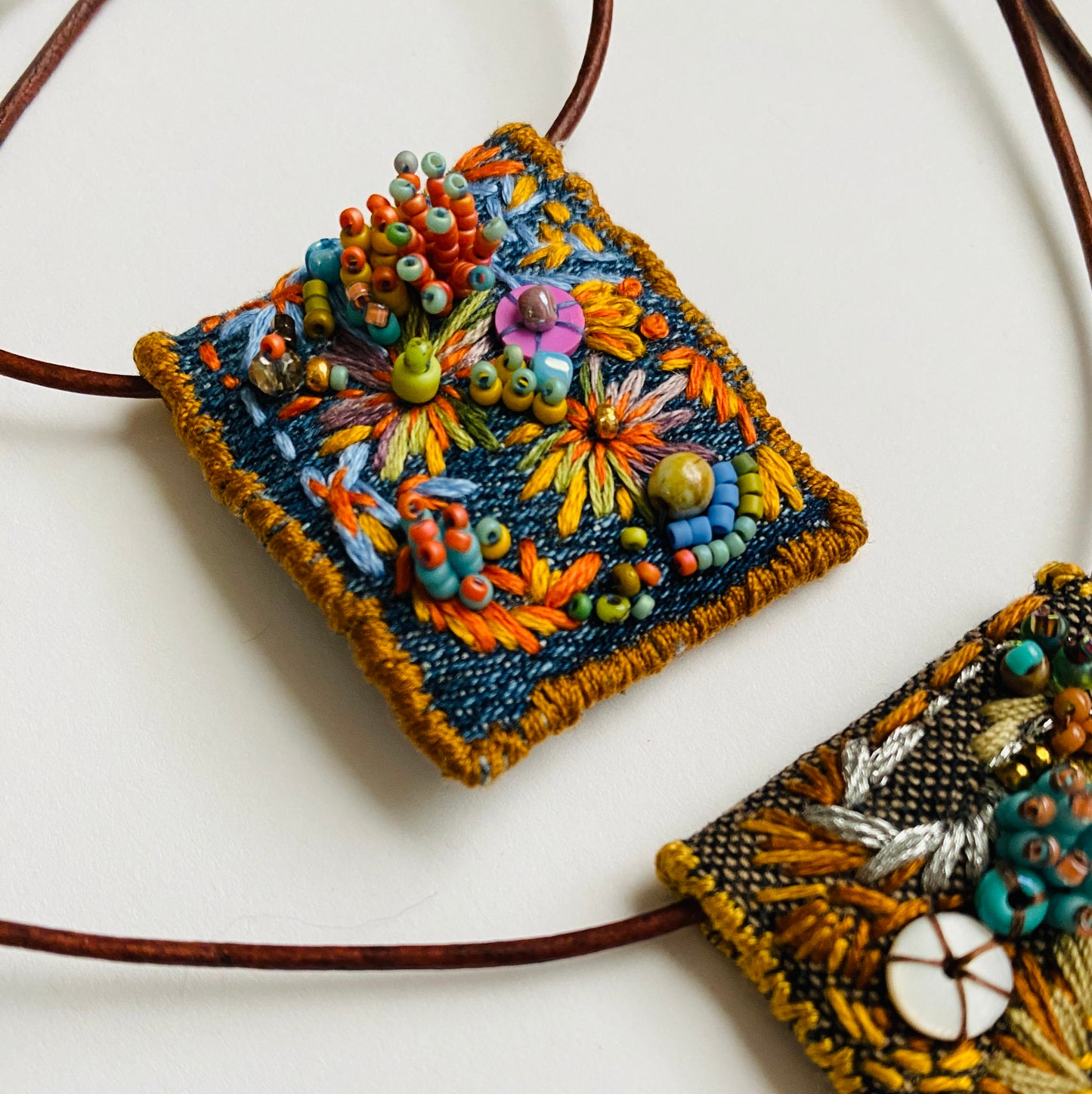 "Zinnias" Light blue and orange embroidered, beaded textile necklace.