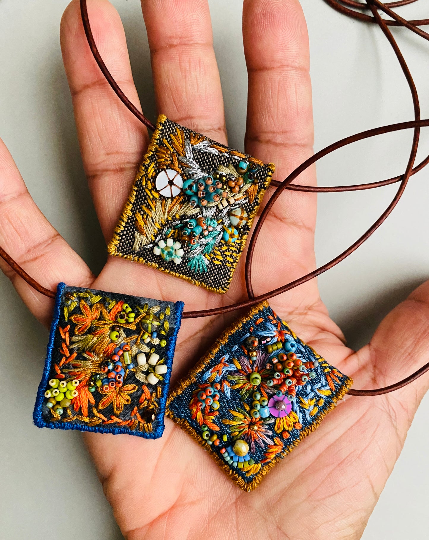 "Zinnias" Light blue and orange embroidered, beaded textile necklace.