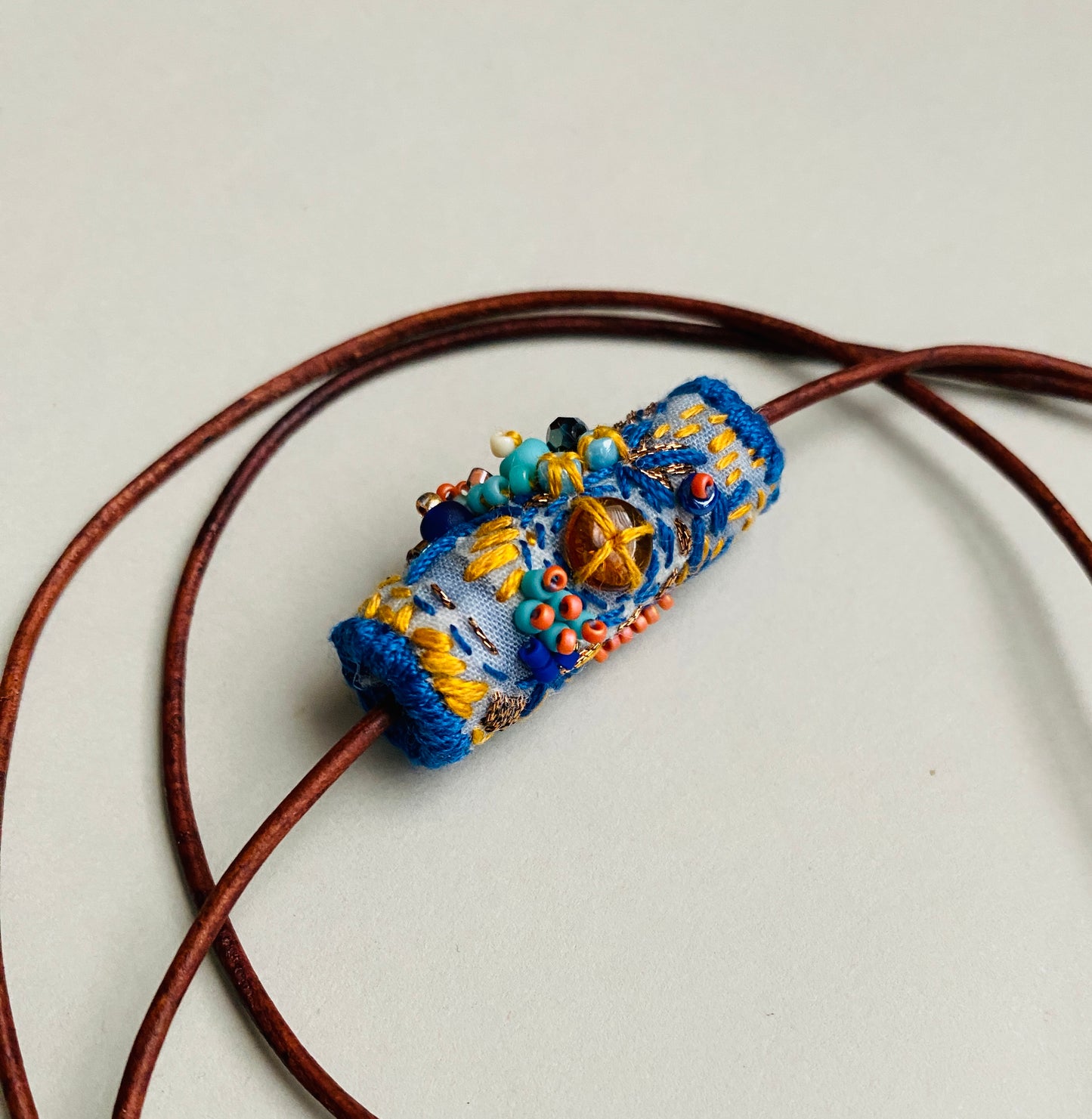 "Oceana" Blue, aqua and orange embroidered and beaded textile necklace.