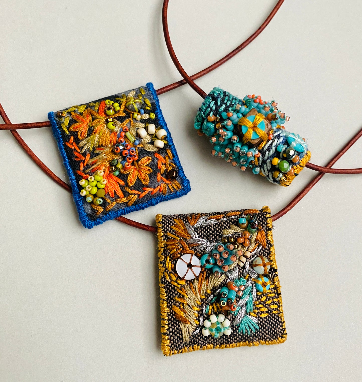 "Flying dove" Aqua, gold, tan embroidered, beaded textile necklace.