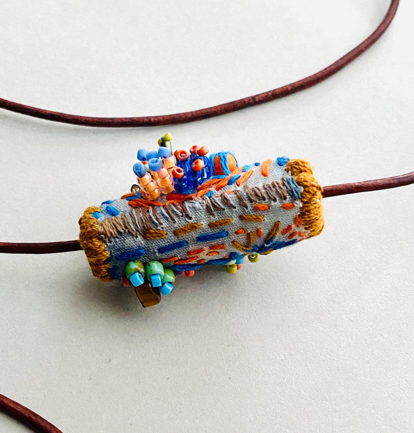 "Horizon" Blue and orange embroidered and beaded textile necklace.