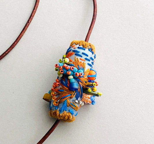 "Horizon" Blue and orange embroidered and beaded textile necklace.